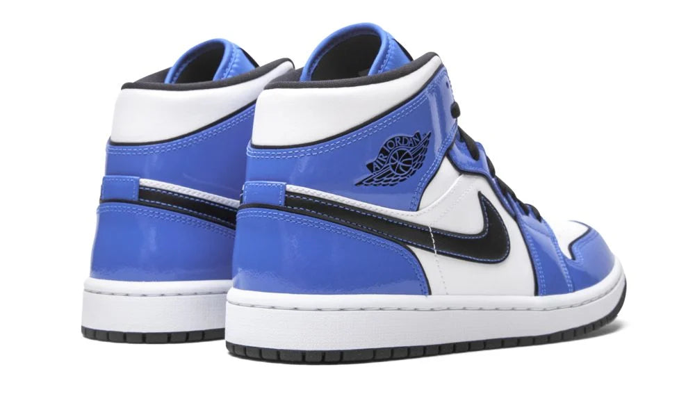 Air Jordan 1 Mid “Signal Blue” – hátulnézet, fekete sarokrész és fehér-kék kombináció